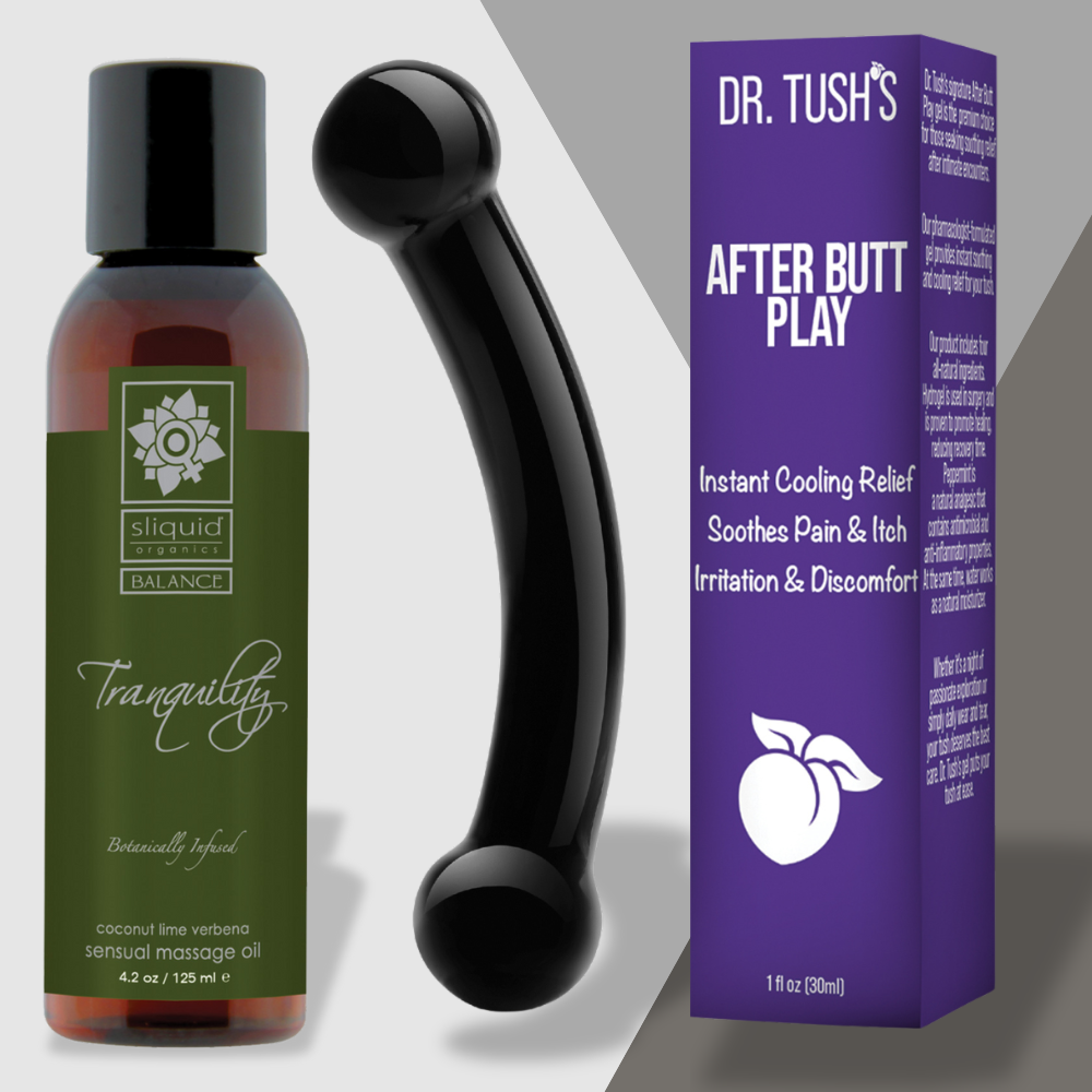 A bottle of Next Morning Realness massage oil from Adams Toy Box sits beside a black ergonomic tool and a purple box labeled Dr. Tushs After Butt Play, offering cooling relief for irritation, making this soothing set perfect for sensual recovery, ensuring relaxation and comfort.