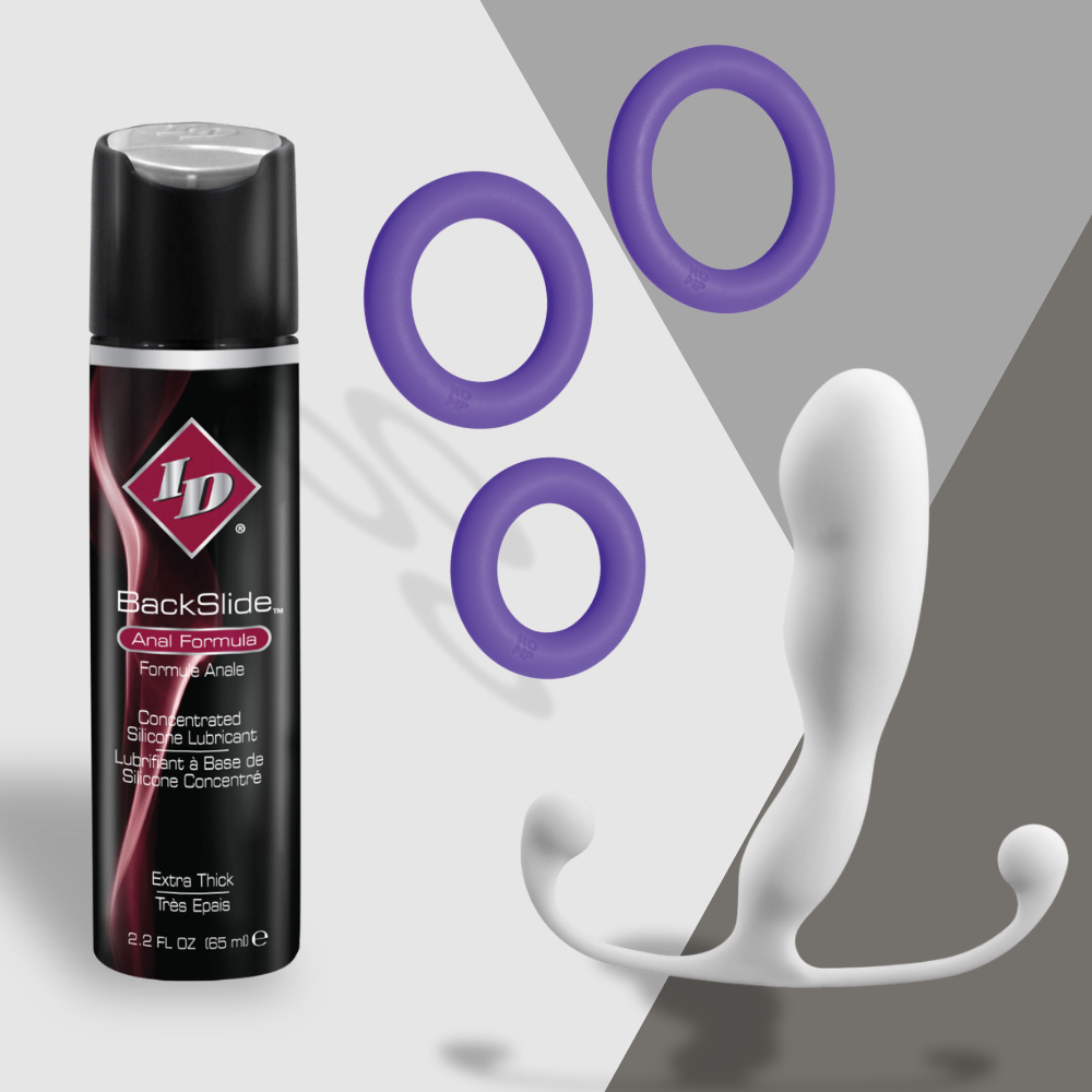 The On-the-Downlow by Adams Toy Box includes a BlackSlide anal formula, three purple silicone rings, and a white prostate massager with a curved handle, all designed for discreet and satisfying fun in a compact size on a gray and white backdrop.