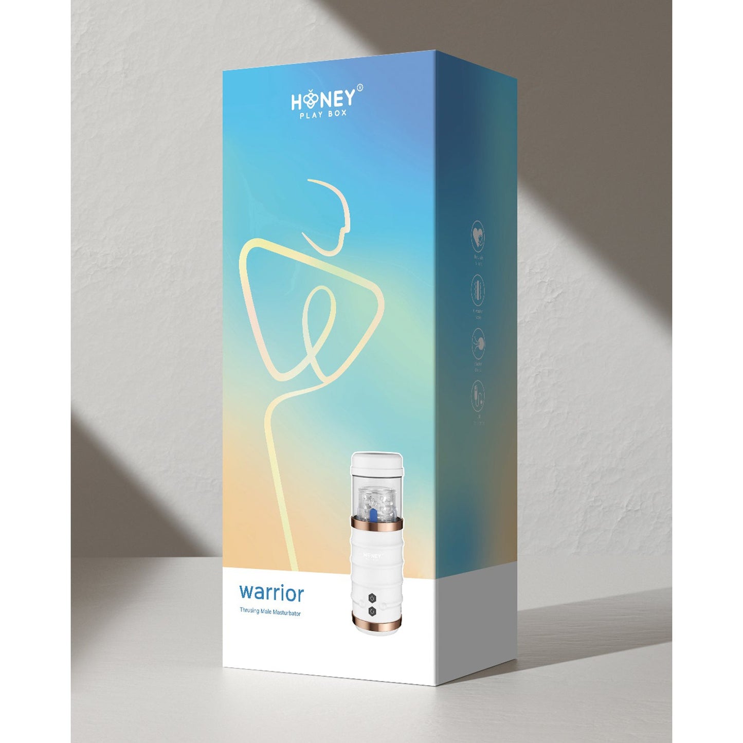 A rectangular box with a gradient design and stylized figure displays the text Honey Play Box and Warrior Auto Thrusting Male Masturbator, featuring an auto-thrusting stroker with a sleek white device and gold base on the front.