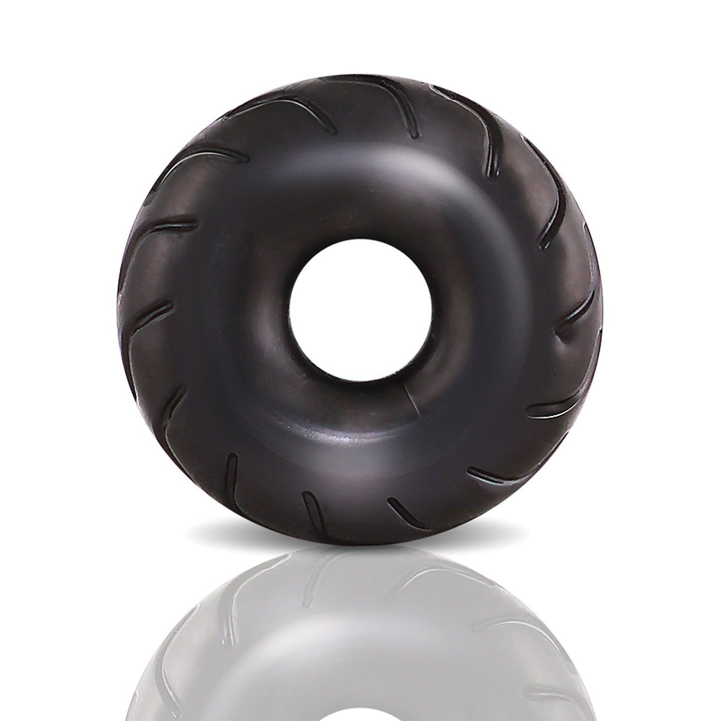 A glossy, black, donut-shaped object made from stretchy X5Plus material with subtle grooves and a central hole resembles the Blush Performance Truck Tire Cock Ring by Blush Novelties. Its shown on a plain white background with a soft reflection beneath.