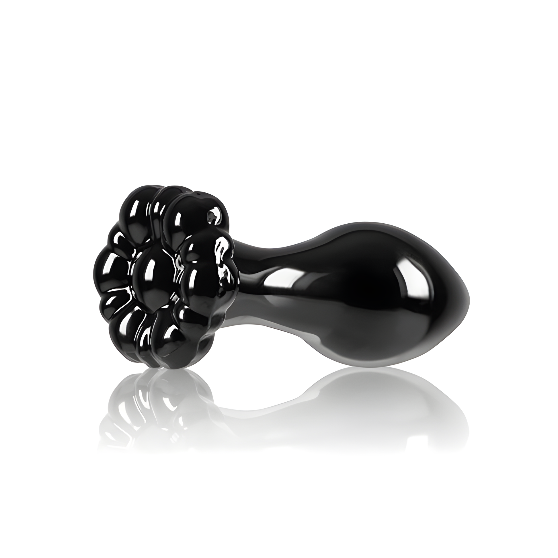 The Crystal Flower Butt Plug by NS Novelties features a glossy black finish resembling a blooming flower with a smooth, bulbous handle. Its reflective surface, similar to borosilicate glass, beautifully catches the light against a white background, showcasing elegant and versatile shapes.