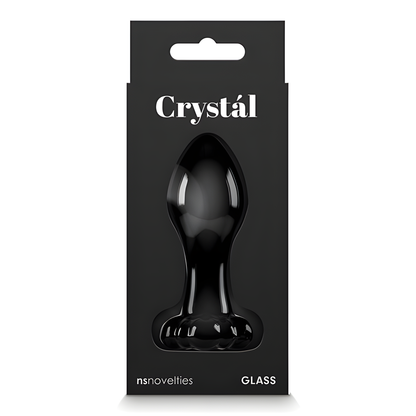 The packaging displays a black glass plug labeled Crystal Flower Butt Plug by NS Novelties, with GLASS at the base. The black background has a window highlighting its elegant form, crafted from durable borosilicate glass.