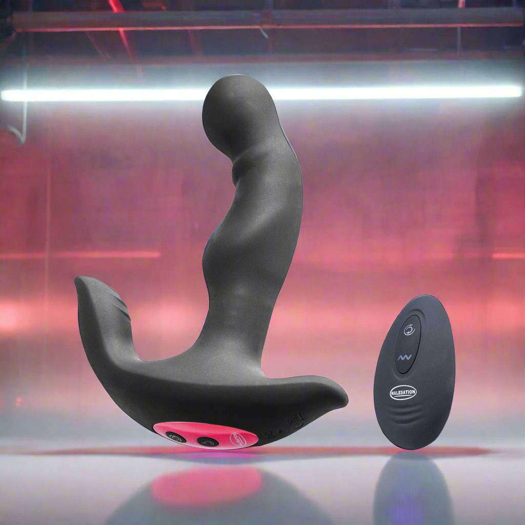 The Malesation Rimming Hero, a black and pink prostate massager with curved design and control buttons, floats next to a sleek black remote. Both are crafted from body-safe silicone and set against a neon-lit pink and purple background. Brand: Malesation.