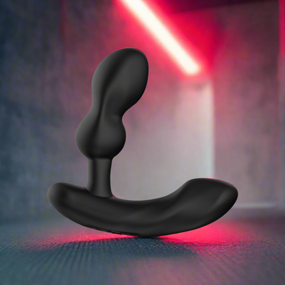 The Lovense Edge 2 Flexible Prostate Massager stands upright on a textured surface. The background features blurred, moody lighting with a red streak, creating a dramatic ambiance reminiscent of the massagers P-spot stimulation design.