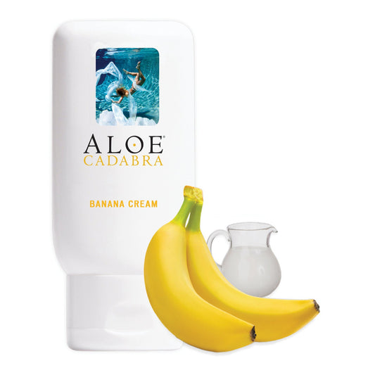 An Aloe Cadabra Organic Lubricant bottle, glycerin-free and enriched with Aloe Vera, is displayed beside two bananas and a milk pitcher, featuring a person swimming underwater.