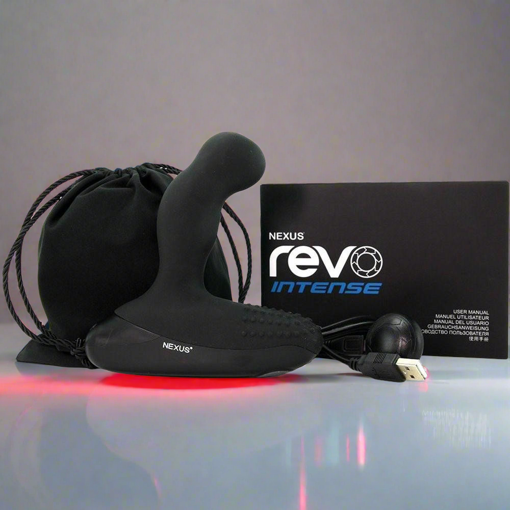 The Nexus Revo Intense Rotating Prostate Massager boasts a smooth silicone build with a curved design and emits a soft red glow. It comes complete with packaging, a black drawstring bag, USB cable, and accessory.