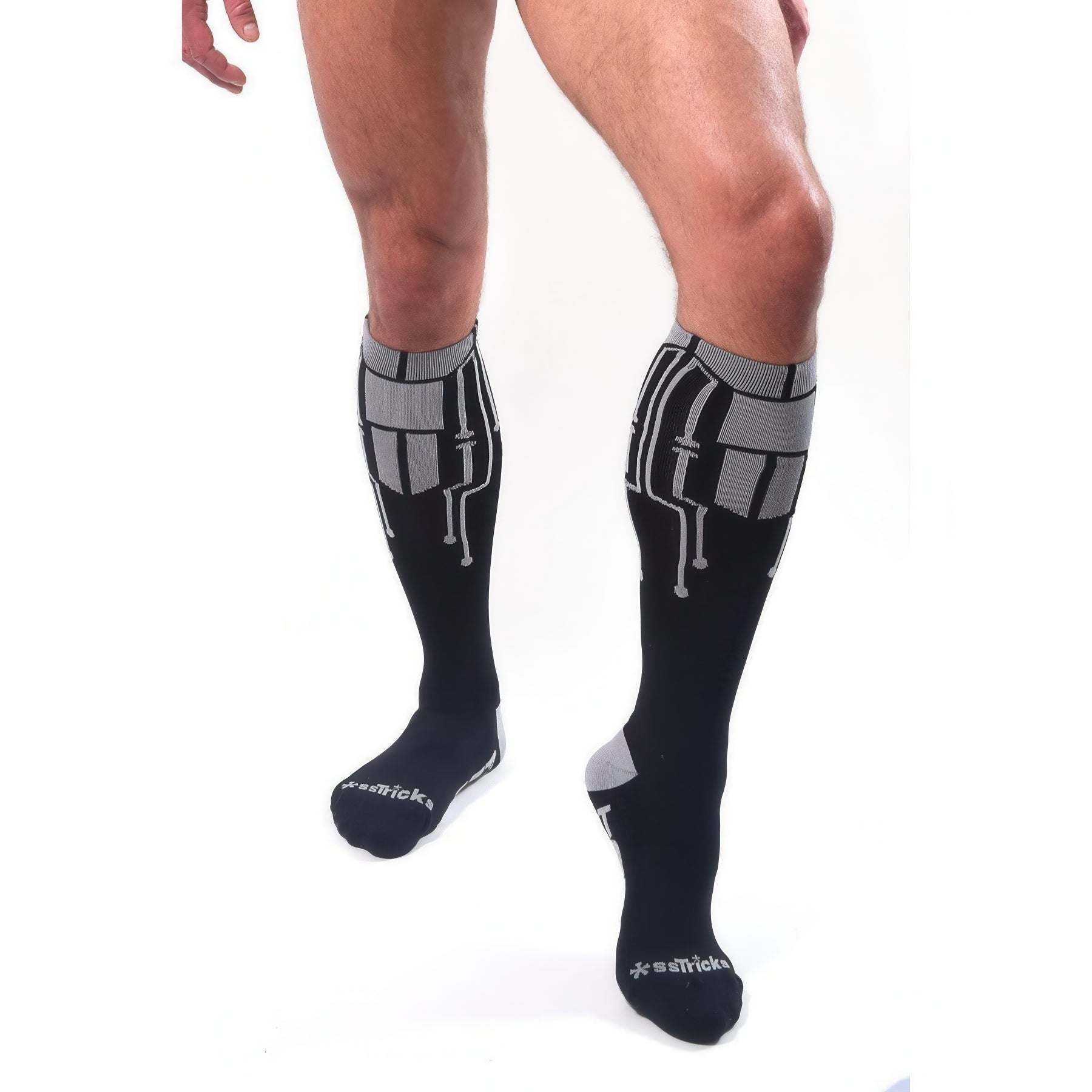 A person models knee-high *ssTricks CyberTech Socks & Black, featuring black, gray, and white geometric patterns, against a plain white background. Only their legs are shown, emphasizing the socks futuristic tech-inspired style.