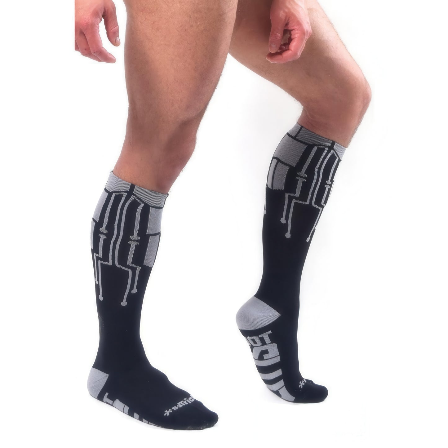 A person models *ssTricks CyberTech Socks & Black with circuit patterns, standing on one leg against a white background—highlighting futuristic style and comfort.