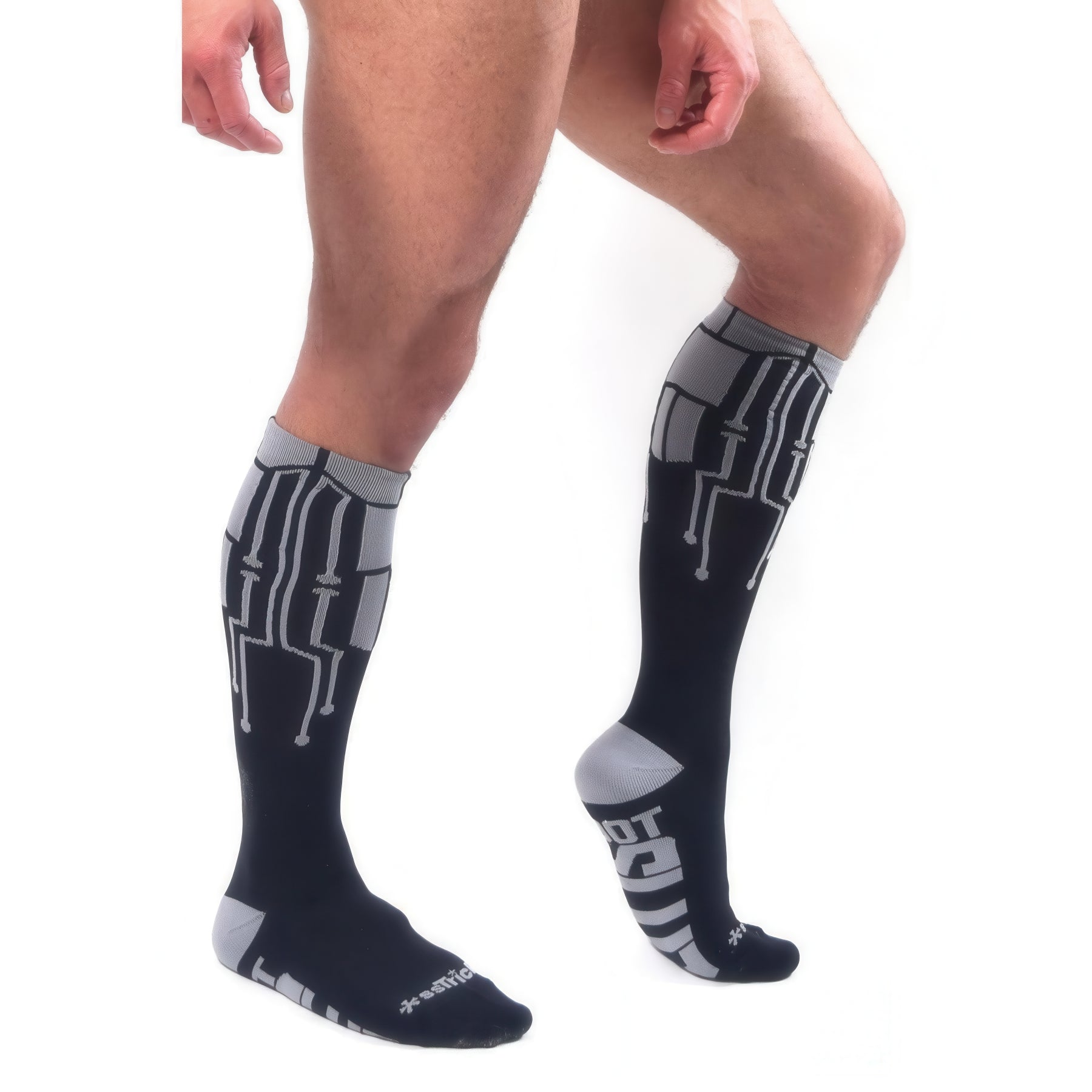 A person models *ssTricks CyberTech Socks & Black with circuit patterns, standing on one leg against a white background—highlighting futuristic style and comfort.