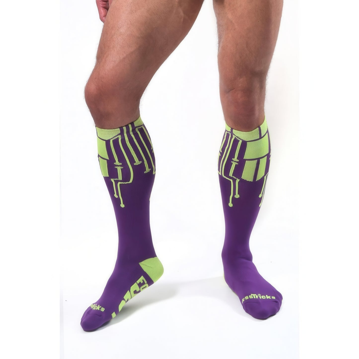A person wearing *ssTricks CyberTech Socks Neon Yellow & Purple—knee-high with a futuristic tech-inspired design—stands on a white background.