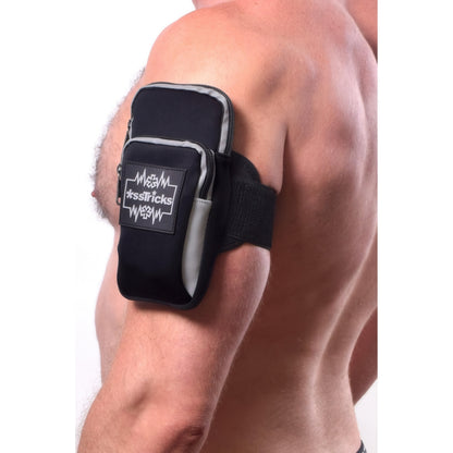 A close-up of a shirtless person’s upper arm wearing the EKG Arm Bag in Black by *ssTricks, made from water-resistant neoprene with a zipper pocket and logo, securely fastened with an adjustable strap.