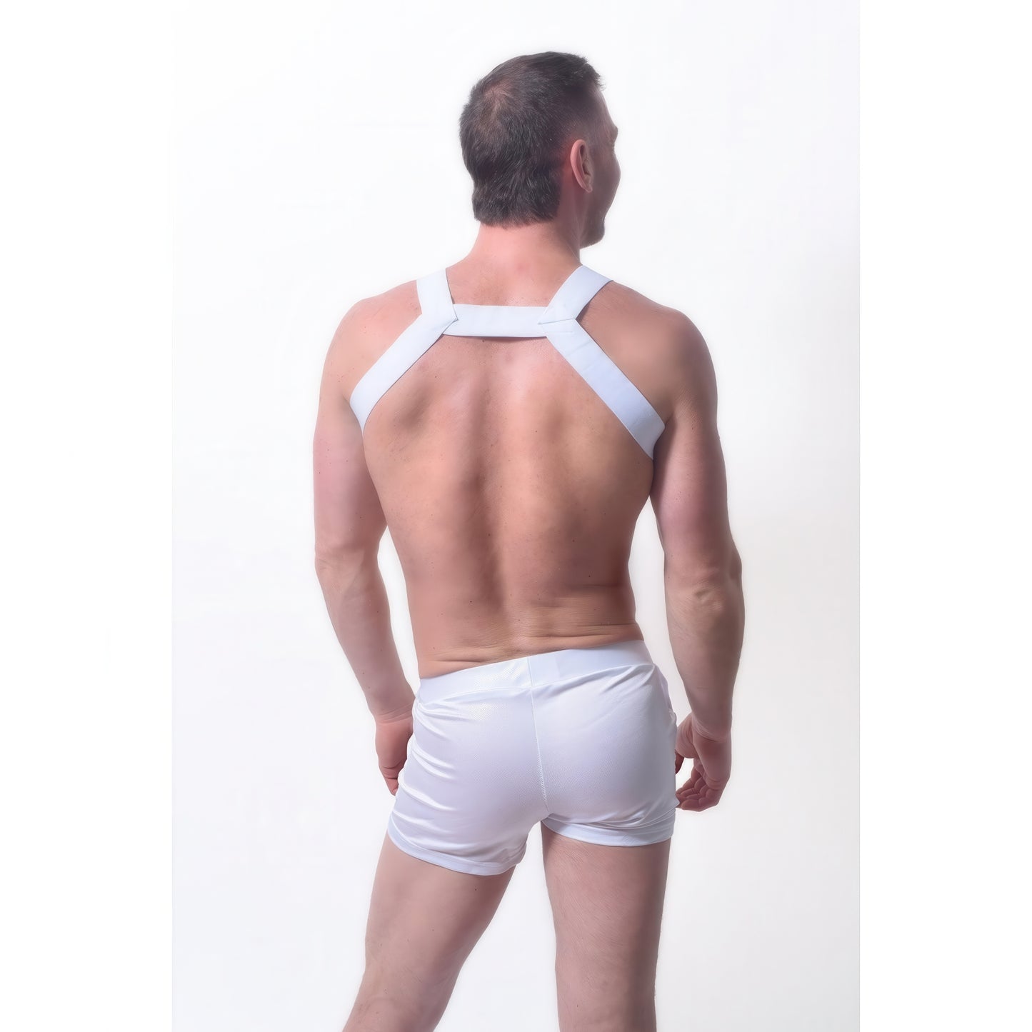 A man stands with his back to the camera, wearing the *ssTricks Transistor Harness in White and matching white shorts against a plain white background.