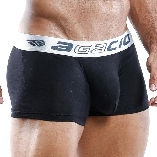 A person models Agacio Boxer Trunk with a contouring pouch for comfort. The black trunk features a white waistband displaying the brand name, and its silky smooth fabric adds luxury. The image highlights the waist and upper thighs.