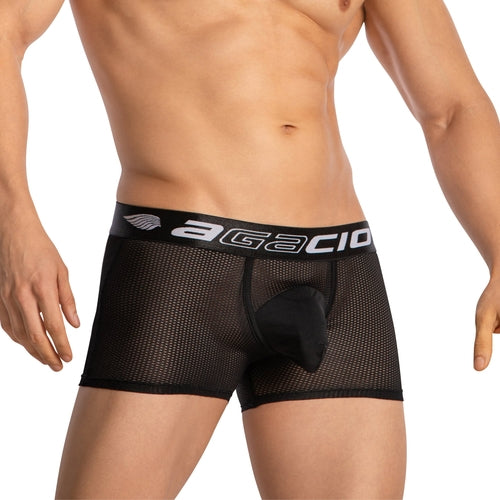 Someone is wearing Agacio Boxer Mesh Trunks with Pouch, featuring a branded waistband. The sheer mesh design ensures a snug fit with a supportive pouch. The background is plain and light-colored.