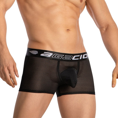 Someone is wearing Agacio Boxer Mesh Trunks with Pouch, featuring a branded waistband. The sheer mesh design ensures a snug fit with a supportive pouch. The background is plain and light-colored.