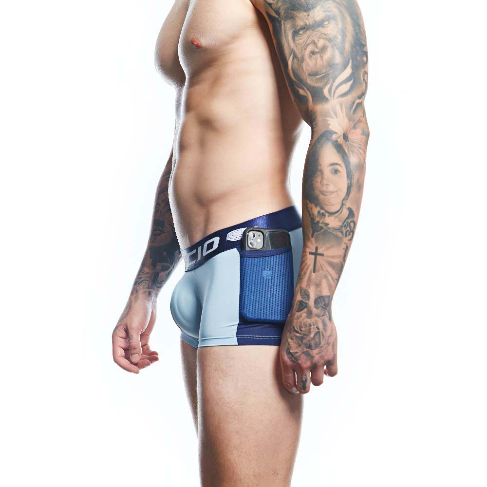 A tattooed person poses in profile, highlighting the comfort and support of Agacio Boxer Trunks Comfortable Underwear. An electronic device decorates the waistband against a plain white backdrop.