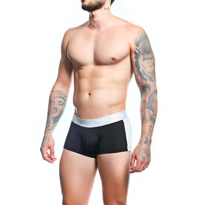 A muscular person with tattoos on their arm and chest wears Agacio Boxer Trunks Comfortable Underwear, standing against a white background and looking to the side.