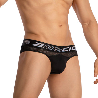 A person wearing Agacio Mens Sheer Briefs with a black mesh design, branded waistband, and contour pouch for comfort and support against a plain white background.