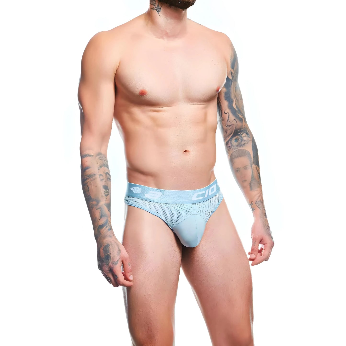 A tattooed muscular model showcases light blue Agacio Thong for Men with a minimalist design; the white background enhances its texture and premium fabric blend.