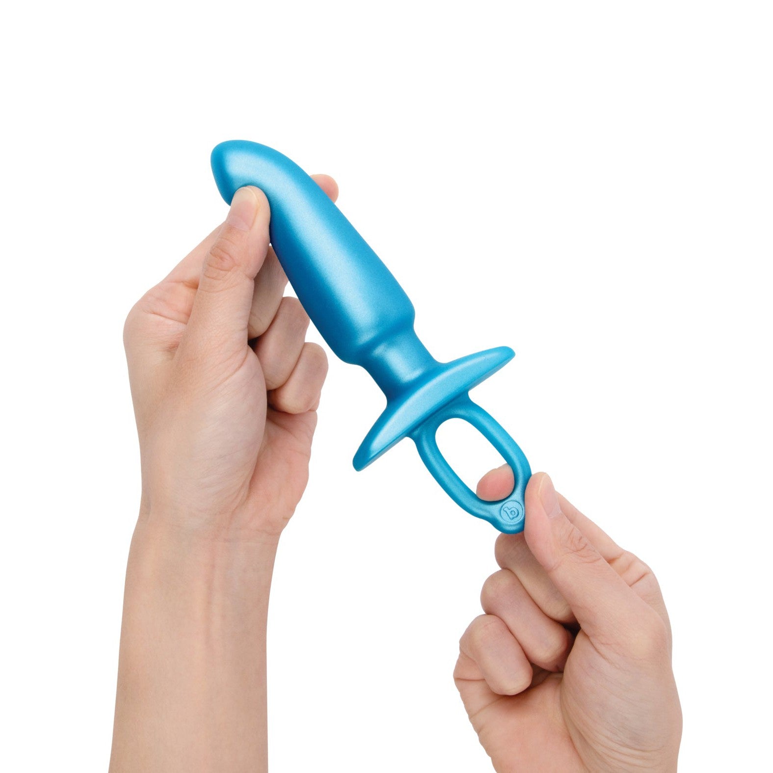 Hands holding the sleek, blue b-Vibe Butties Hither Tapered Prostate Plug, crafted from silicone for optimal P-spot stimulation, and featuring an ergonomic shape with a handle at the base against a white background.
