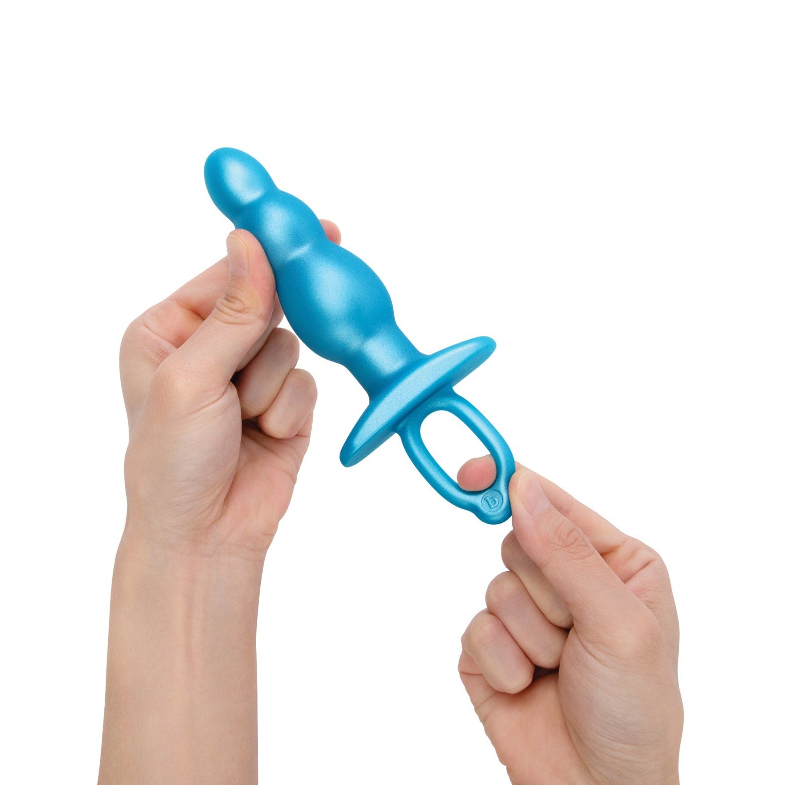A person holds the b-Vibe Butties Bounce Beaded Tapered Plug in blue silicone with a pull ring, ideal for anal training. The background is white.