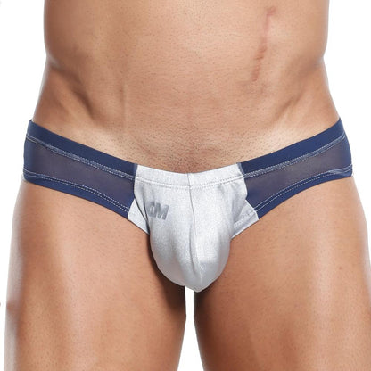 Someone is wearing a blue and silver Cover Male Slip Thong with sheer and solid elements, featuring mesh panels at the sides. It emphasizes the midsection and hips while providing supportive hold.