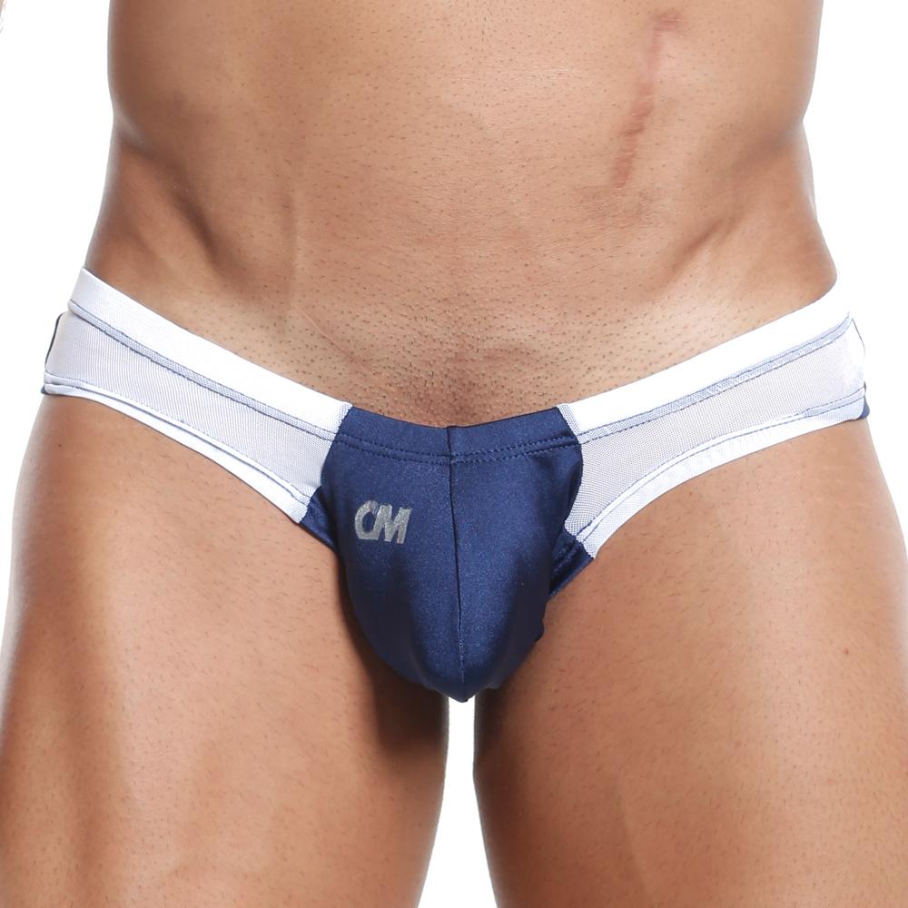 A person in the Cover Male Slip Thong, a blue and white thong with supportive hold, displaying visible abs. This sleek design features CM on the front, blending sheer and solid elements for an attractive appearance.