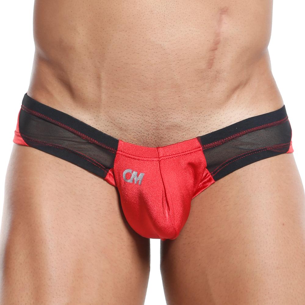 Someone is wearing red and black Cover Male Slip Thong briefs featuring mesh sides for a sheer and solid look, with CM initials on the front. The supportive fit accentuates their torso while their face is not visible.