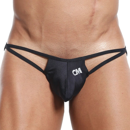 A close-up shows a person in a black Cover Male G-String, highlighting its sleek design, thin straps, minimal coverage, and a small CM logo on the waist and upper thighs.