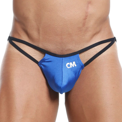 A person wears a Cover Male G-String in blue and black with CM on the front, focusing on the lower torso and waist, highlighting its minimal coverage and contoured pouch design.