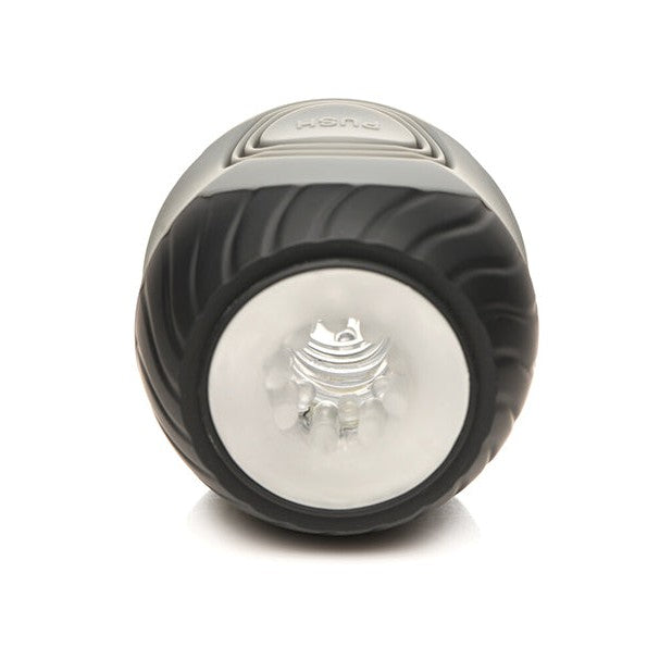 The Curve Toys Jock 10x Vibrating Double Masturbator by Curve Novelties, featuring a black cylindrical design with a clear lens and spiral grip, offers sophistication. This dual-ended device includes 10 vibration modes, a top push button, and rests elegantly on any smooth surface.