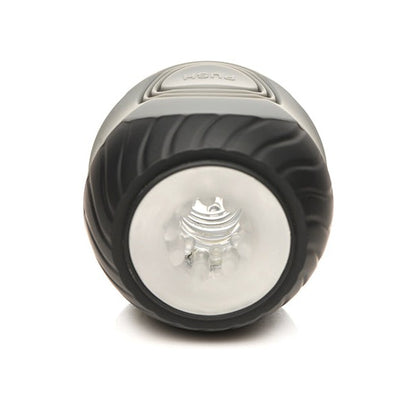 The Curve Toys Jock 10x Vibrating Double Masturbator by Curve Novelties, featuring a black cylindrical design with a clear lens and spiral grip, offers sophistication. This dual-ended device includes 10 vibration modes, a top push button, and rests elegantly on any smooth surface.