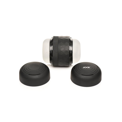 The Curve Toys Jock Squeezable Tunnel Double Masturbator by Curve Novelties features a cylindrical black design with textured grips and frosted ends. It includes two cap-like parts, with JOCK visible on one cap, and offers variable tightness settings, set against a plain white backdrop.