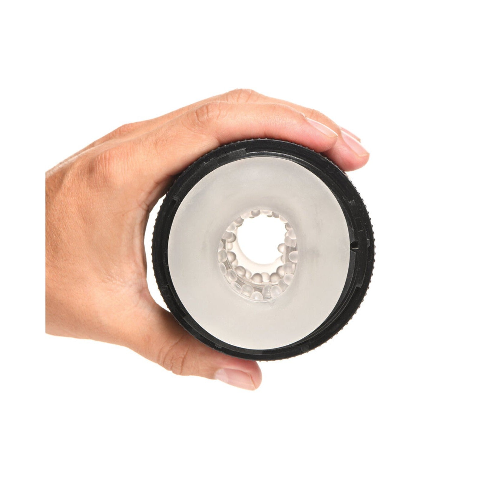 A hand holds a cylindrical black object with a transparent top, revealing small white beads inside. This textured item might be part of the Curve Toys Jock Squeezable Tunnel Double Masturbator by Curve Novelties, featuring customizable tightness settings.