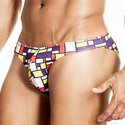 Someone wearing Daniel Alexander Art-Deco Fritz Bikini Briefs, featuring a vibrant geometric print with red, yellow, white, and purple squares and rectangles.