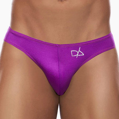 A person wears vibrant purple Daniel Alexander Colorful Slip bikini briefs featuring a sexy contoured pouch and a small white logo on the left. The image focuses on the waist and torso, highlighting the fit and color against a plain background.