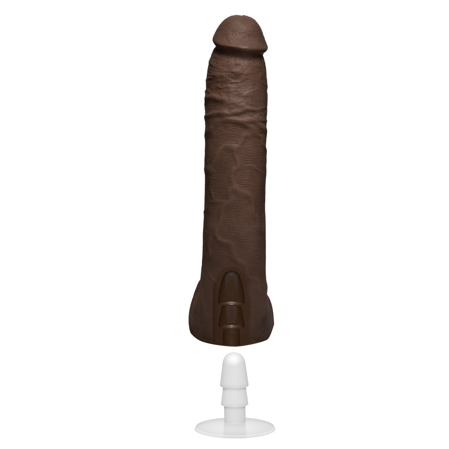 The Signature Cocks ULTRASKYN 10 by Doc Johnson is a dark brown, dual-density silicone sculpture resembling male genitalia, displayed upright on a white stand with a suction cup base.