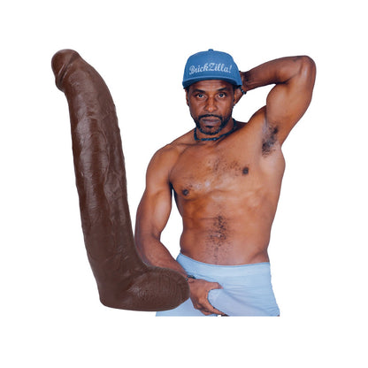 A shirtless man in a blue cap confidently poses, one arm behind his head and the other on his waistband, next to Doc Johnsons Signature Cocks ULTRASKYN 13 Cock - Brickzilla. The plain white background enhances the bold dual-density design of the large brown sculpture beside him.