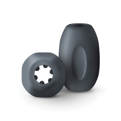 Explore the Boners Hand Job Stroker set: two dark gray ultra-soft cylindrical toys. One has a smooth surface with an oval indentation; the other offers a circular opening and inner protrusions for intense stimulation.