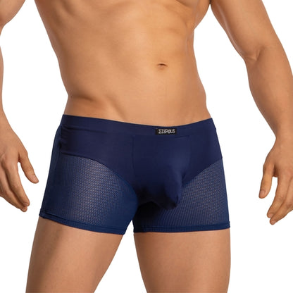 An individual is modeling Edipous Boxer Briefs for Men with Breathable Mesh, featuring a solid front panel and navy blue airy mesh sides, accentuating their torso and muscular arms against a plain white background.