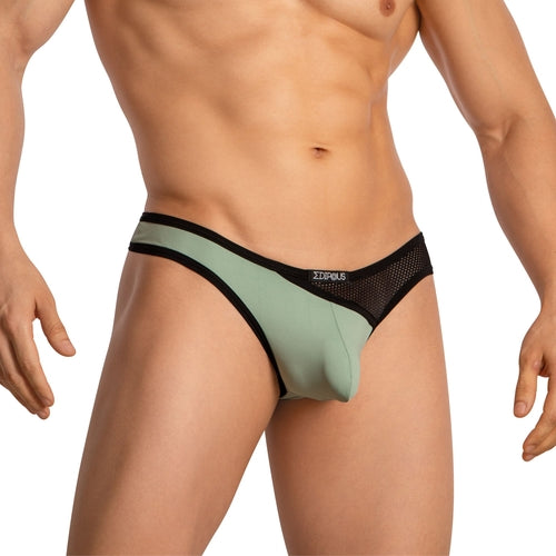 A person sports a light green and black Edipous Mens Thong with an asymmetrical cut. The photo highlights the midsection, showcasing the stylish design, fit, and waistband logo of this Edipous underwear.