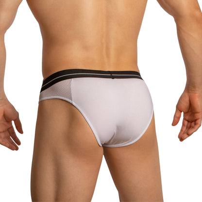 A person is shown from the back wearing Feel Thongs for Guys by Feel, featuring white briefs with a black waistband and mesh side panels for breathability. Their hands rest relaxed at their sides.