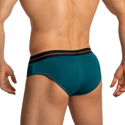 A person is shown from the back wearing Feels teal Feel Thongs for Men with a black waistband, made from a luxurious fabric blend for minimal coverage, against a plain white background.
