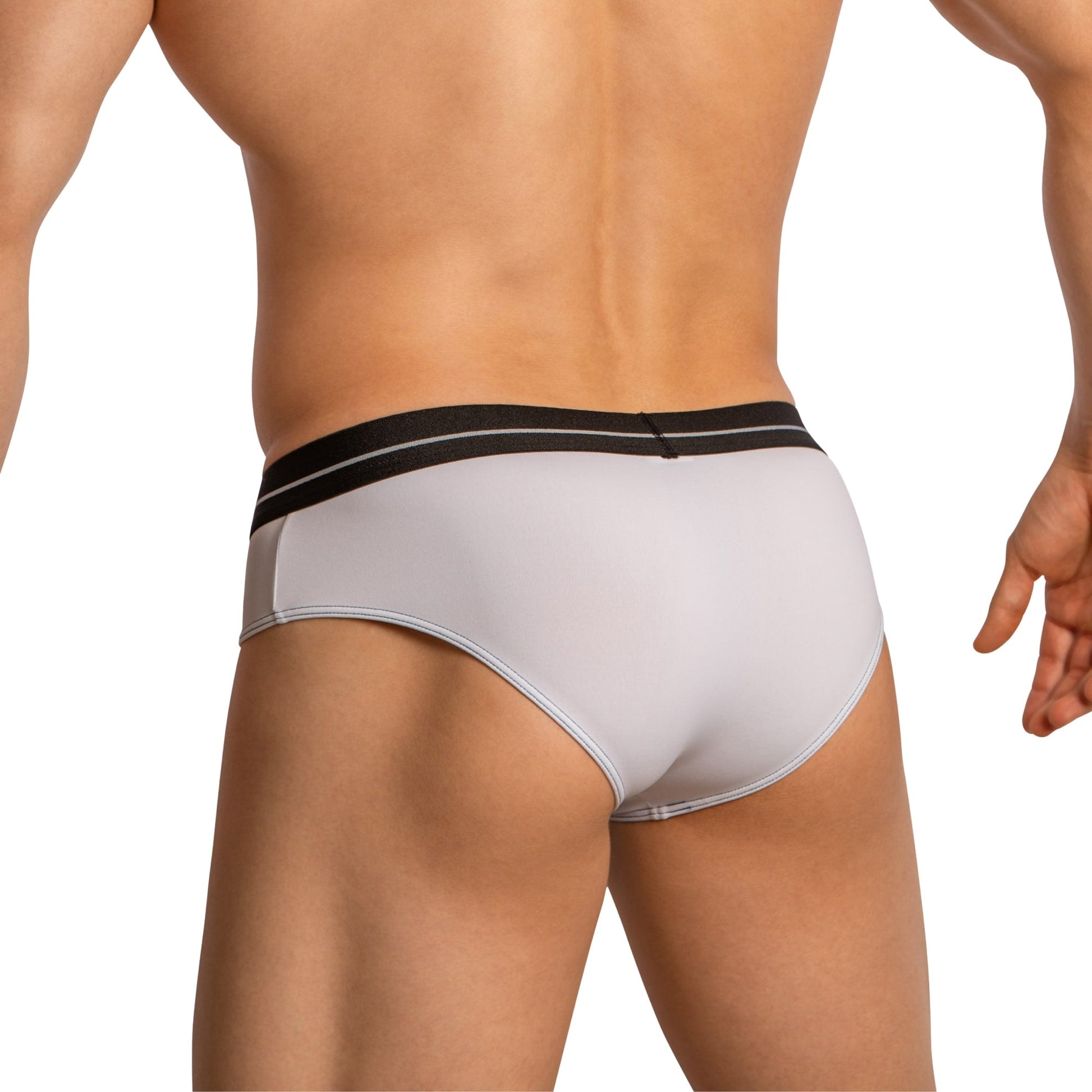 A person is shown from the back wearing Feel Thongs for Men, featuring a white thong with a black waistband that highlights its minimal coverage and stylish fit in a luxurious fabric blend.
