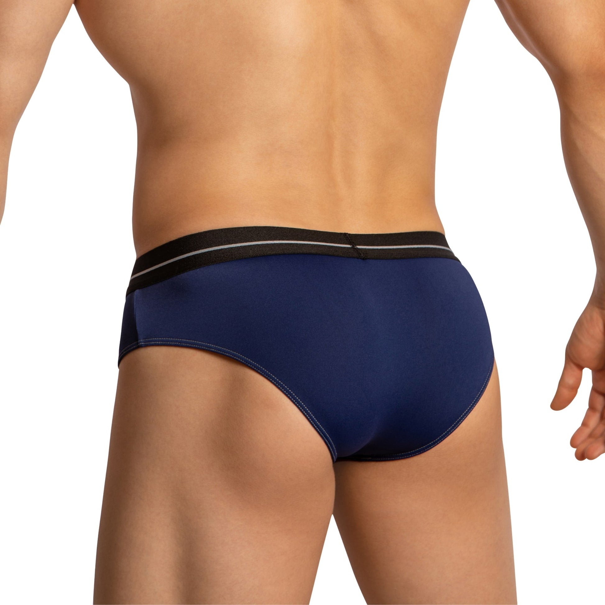 The image showcases a person in Feels luxurious Feel Thongs for Men with a navy blue design and black waistband, highlighting the back view. The comfortable fabric blends well with light skin tones against a white backdrop.