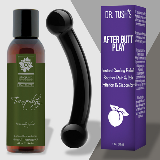 A bottle of Next Morning Realness massage oil from Adams Toy Box sits beside a black ergonomic tool and a purple box labeled Dr. Tushs After Butt Play, offering cooling relief for irritation, making this soothing set perfect for sensual recovery, ensuring relaxation and comfort.