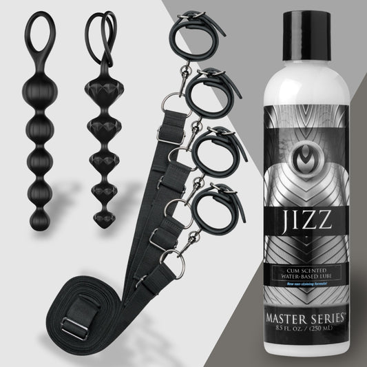 The image showcases Rough and Ready by Adams Toy Box, featuring black restraint cuffs linked by a strap, two sleek black bead toys, and a bottle of water-based lubricant labeled Master Series against a minimalist gray two-tone background.