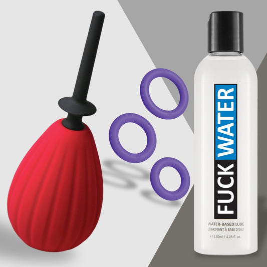 The Date Night Disaster Fixer from Adams Toy Box featuring a red bulb enema with a black nozzle, three purple silicone cock rings, and a bottle of Fuck Water lube rests on a light gray background.