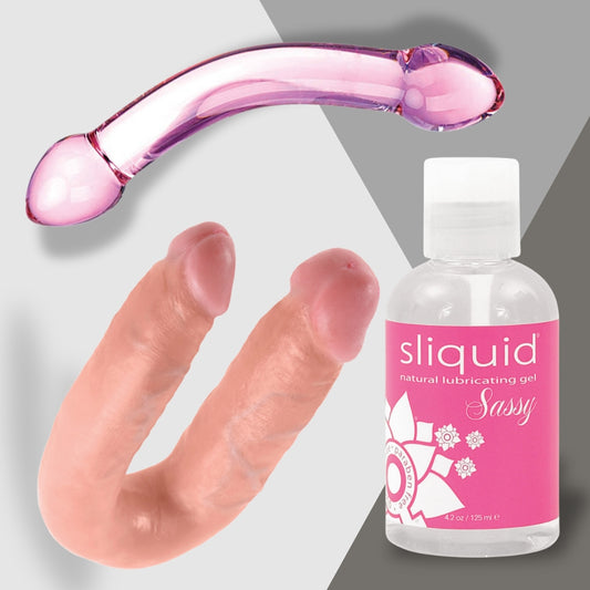 The image features Adams Toy Box products: a pink glass dildo, the Double or Nothing flesh-toned double-ended dildo, and Sliquid Sassy natural lubricating gel. Perfect for couples seeking fun and satisfaction, the backdrop is split into gray and white sections.