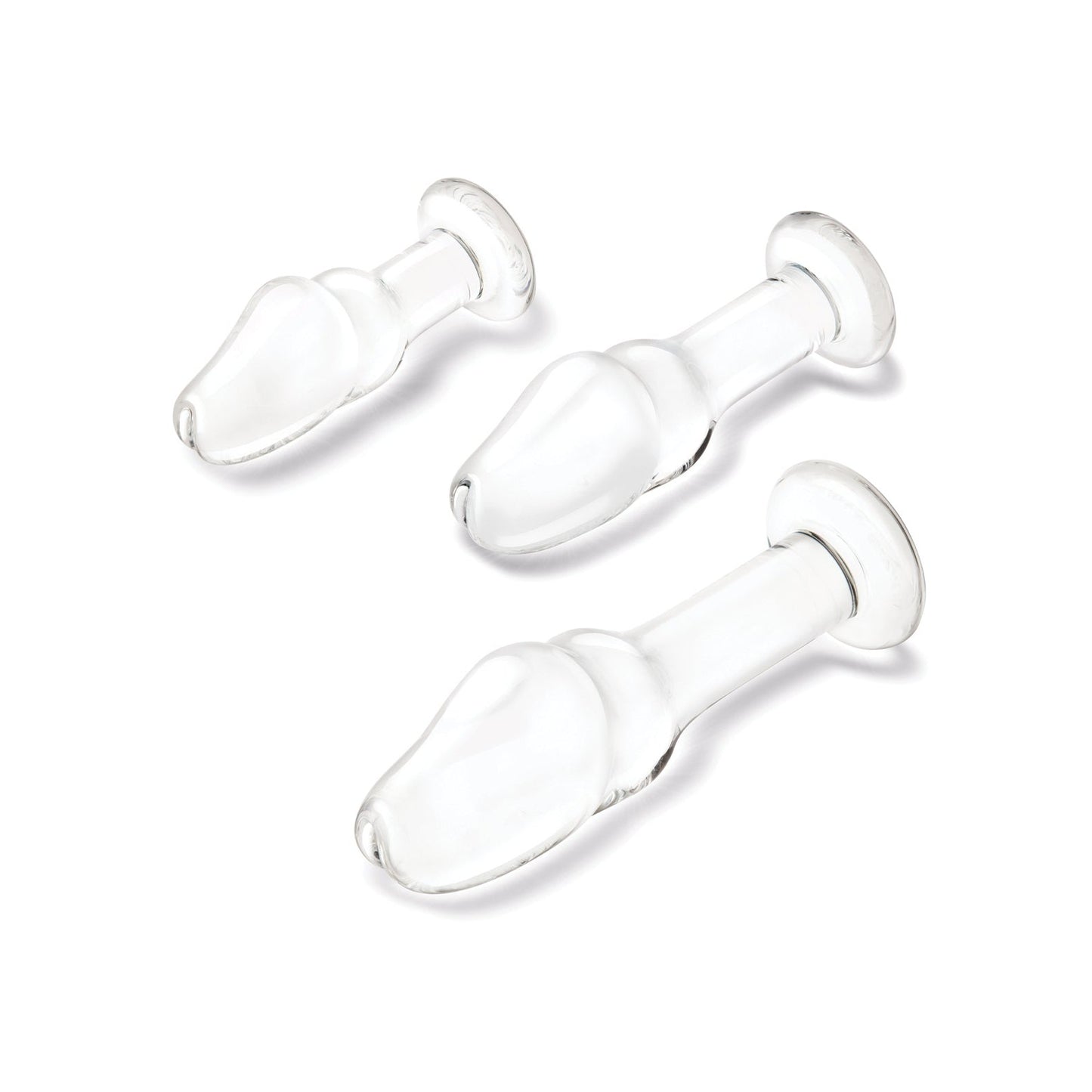 A set of three transparent, glass items in the Glas Helmet Head Anal Training Kit by Gläs features varying sizes on a white background. Each has a bulbous, helmet-shaped design with a wide end tapering to a narrow stem and flat base for temperature play exploration.